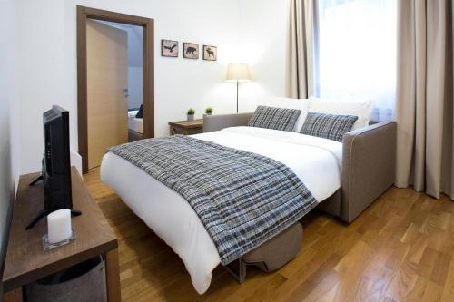 una camera con un letto e una televisione di Apartman DUSA a Kopaonik