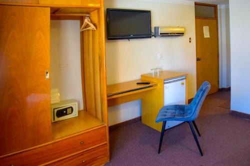 a room with a desk and a blue chair at Casona Plaza Balsa Inn in Puno