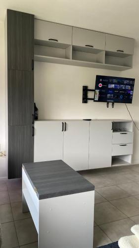 cocina con armarios blancos y TV de pantalla plana en Monoambiente La Plata departamento en La Plata