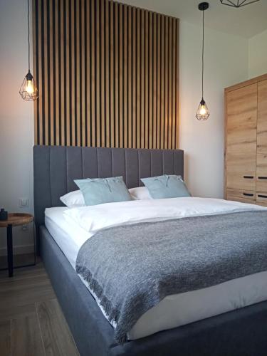 Un dormitorio con una cama grande con dos almohadas. en Apartament SEVENTH HEAVEN, en Uniejów