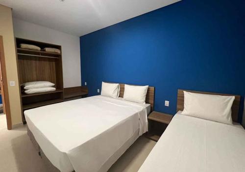 a bedroom with two beds and a blue wall at São Pedro Thermas Resort Oficial in São Pedro