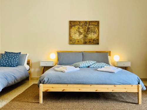 - une chambre avec un lit avec des draps bleus et deux lampes dans l'établissement Mita Apartments, à Catane