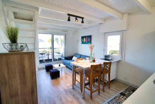 une cuisine et un salon avec une table et des chaises dans l'établissement Duplex en bord de mer, à Carnac