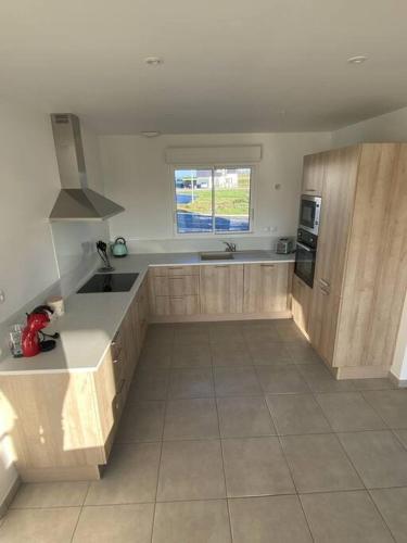 une cuisine avec un évier et un plan de travail dans l'établissement Entre mer et campagne, à Campigneulles-les-Grandes