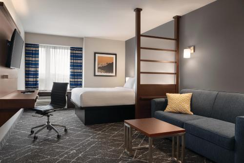 um quarto de hotel com uma cama e um sofá em Microtel Inn & Suites by Wyndham Antigonish em Antigonish