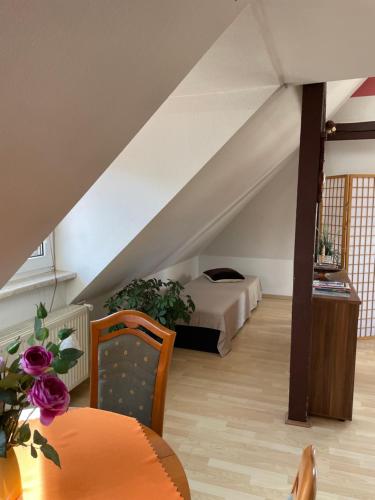 een zolderkamer met een bed en een tafel en stoelen bij Urlaub beim Fürst in Wernigerode
