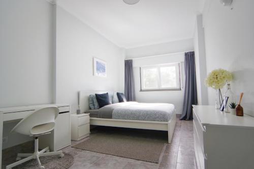 um quarto branco com uma cama e uma secretária em Casa Emon Cascais New Mordern Apartment 3 Bedrooms em Cascais