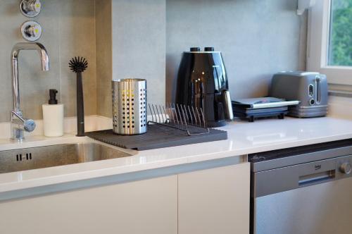 a kitchen counter with a sink and a coffee maker at Casa Emon Cascais New Mordern Apartment 3 Bedrooms in Cascais