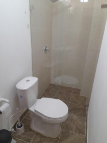 La salle de bains est pourvue d'une douche et de toilettes blanches. dans l'établissement Casa hotel hispania 2, à Hispania