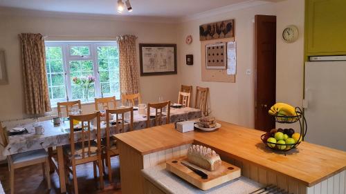 cocina y comedor con mesa y sillas en Wey House en Withypool