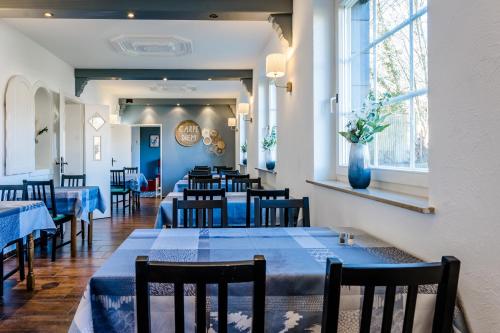 Hotel am See في Kreuzau: غرفة طعام مع طاولات وكراسي زرقاء