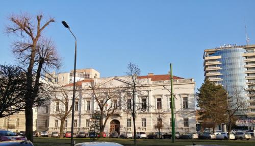 a white building with a street light in front of it at Casa Clau in Arad
