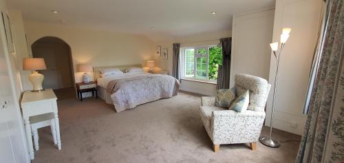 a bedroom with a bed and a chair and a window at Wey House in Withypool