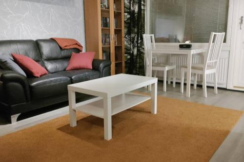 a living room with a couch and a table at Kodikas yksiö keskustassa omalla autopaikalla in Joensuu