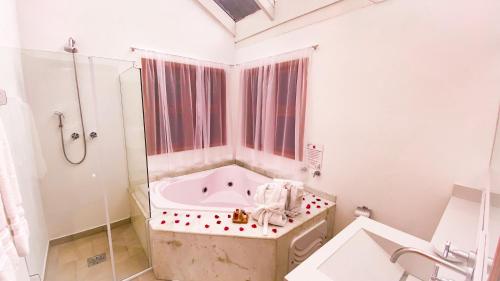 a white bathroom with a tub and a shower at Pousada O Cantinho da Raposa in Monte Verde