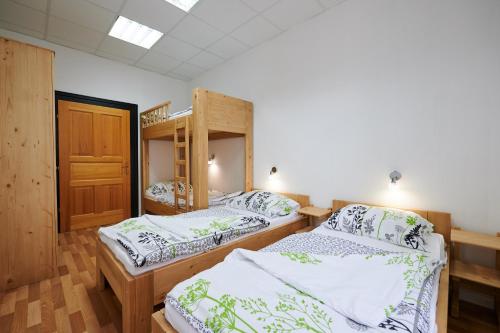 a room with two beds and a bunk bed at Hostel Mladinski center Šmartno ob Paki in Šmartno ob Paki