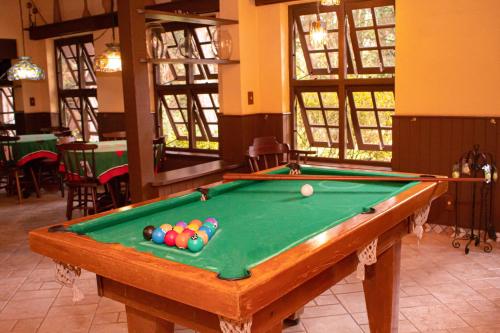 a pool table with balls on it in a room at Pousada O Cantinho da Raposa in Monte Verde