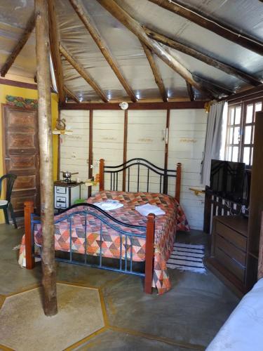 ein Schlafzimmer mit einem Bett in einem Zimmer in der Unterkunft CHALE e SUÍTE com Mimos Café Manhã in Lumiar