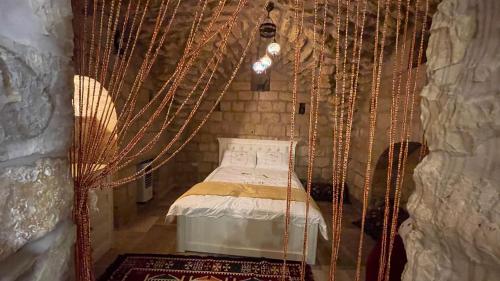 una camera con un letto in una stanza con le catene di Palace of Sultan Jalal Basha ad Abū Ghaush