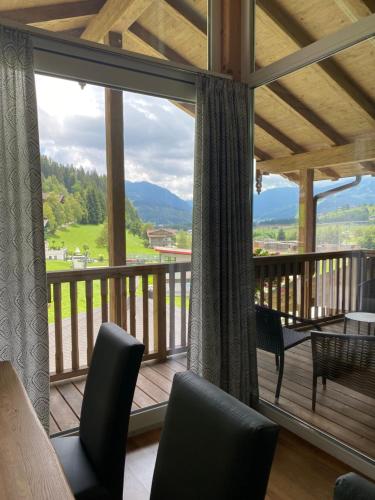 a room with a balcony with a view of the mountains at Landhotel Berger in Eben im Pongau