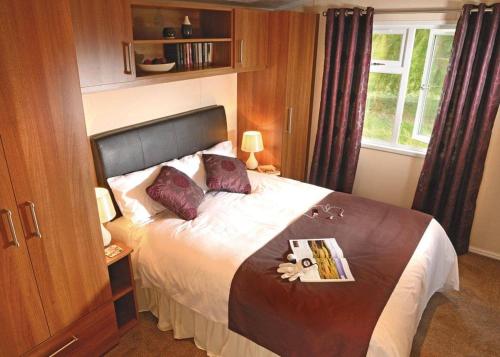 a bedroom with a bed with a book on it at Tydd St Giles Resort in Wisbech