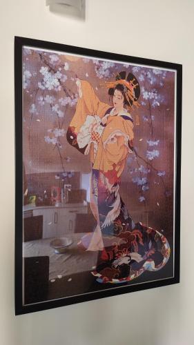 a painting of a woman with an umbrella on a wall at Mi Casa en Guriezo in Angostina