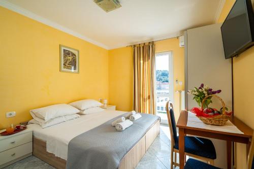 a bedroom with a bed and a desk and a television at Apartmani Niki ZVEKOVICA in Cavtat