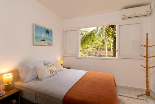 Un dormitorio con una cama grande y una ventana en Casa Amarela, en Angra dos Reis