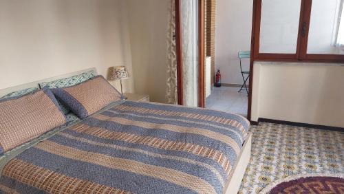 a bedroom with a bed with a blue comforter at Appartamento da Miriam in Lido di Ostia