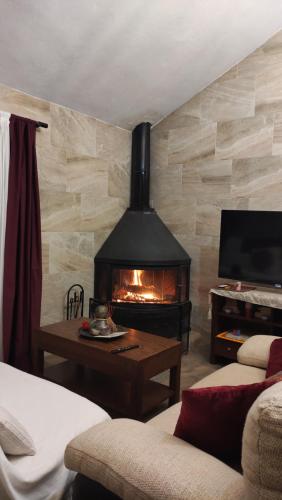 a living room with a fireplace and a tv at Casa rural La Pradera in Villanueva de la Concepción