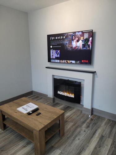 a living room with a fireplace and a flat screen tv at Horseleap BNB in Moate