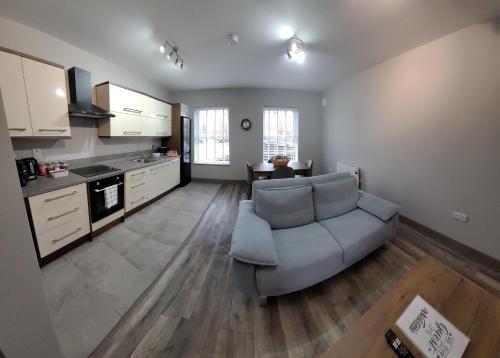 a living room with a couch and a kitchen at Horseleap BNB in Moate