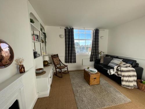 a living room with a couch and a window at Ashcroft Hall - Converted Chapel in Central Cirencester in Cirencester