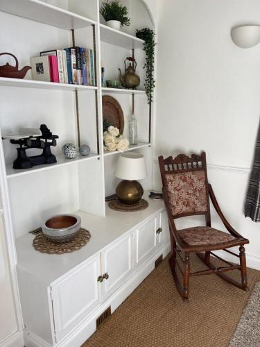 a room with a chair and a book shelf at Ashcroft Hall - Converted Chapel in Central Cirencester in Cirencester