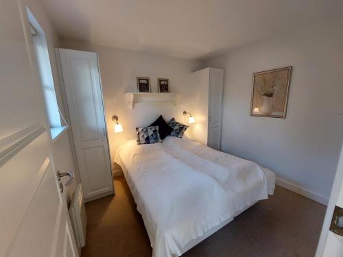 1 dormitorio con 1 cama blanca grande y 2 almohadas en Wounderful holiday house with wifi, spa & sauna, en Gjern