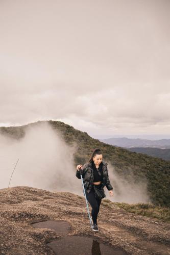 a woman running on a dirt road with a rope at Pousada O Cantinho da Raposa in Monte Verde