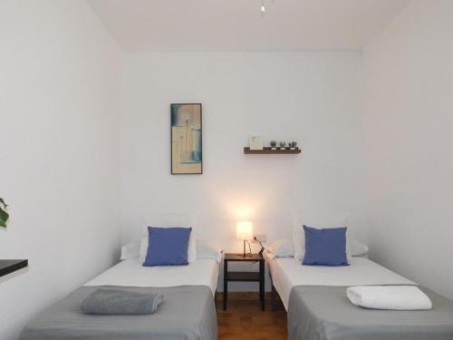 een kamer met 2 bedden en blauwe kussens bij Encantadora casa Benajarafe in Benajarafe