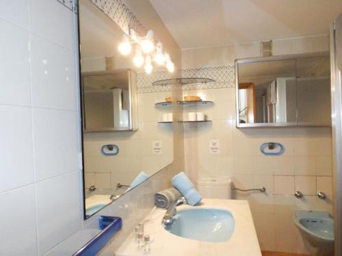 een badkamer met een wastafel, een spiegel en een toilet bij Encantadora casa Benajarafe in Benajarafe