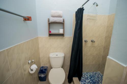 a bathroom with a toilet and a black shower curtain at La Pintada Inn in La Pintada