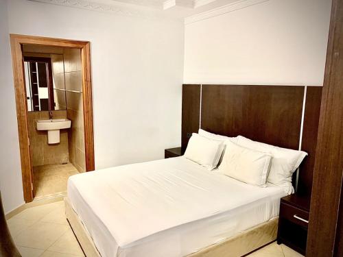 a bedroom with a white bed and a sink at HOTEL BEAUTIFUL in Nador