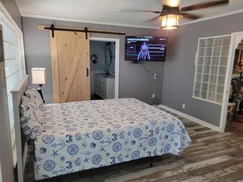 a bedroom with a bed and a tv on the wall at WaterFront Mid Century Cottage - Close to beach - 2 BR 3 BA in Ruskin