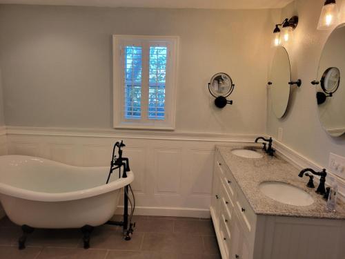 a white bathroom with two sinks and a tub at WaterFront Mid Century Cottage - Close to beach - 2 BR 3 BA in Ruskin