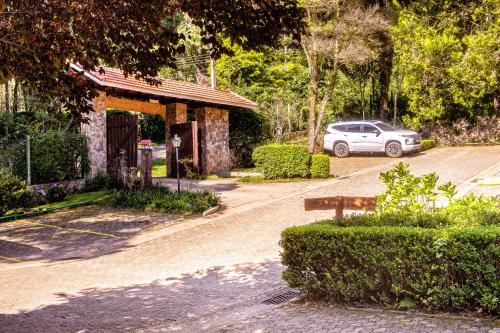 a car parked in front of a building with a car at Pousada O Cantinho da Raposa in Monte Verde