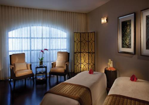 een hotelkamer met 2 bedden en stoelen en een raam bij Omni Las Colinas Hotel in Irving