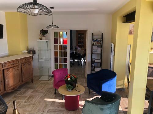 a living room with colorful chairs and a table at La Villa Port Winston - Face Mer B&B in Saint-Côme-de-Fresné