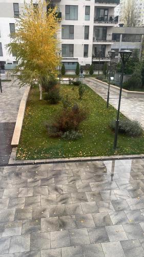 un parque frente a un edificio con un árbol en Apartament Lux Citta Residence, en Bucarest