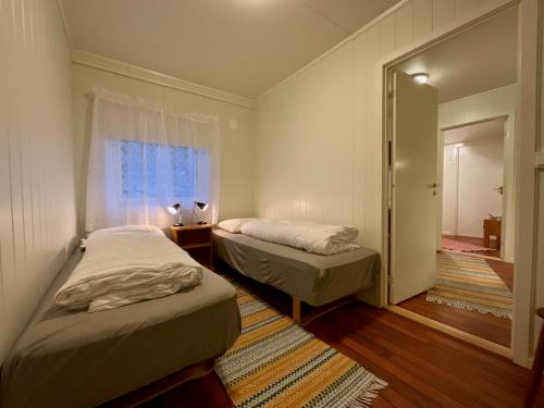 2 camas en una habitación pequeña con ventana en Fishermans Rorbu 2 - Lofoten, en Ramberg