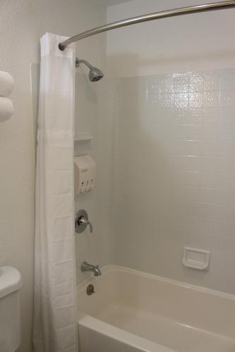 a bathroom with a white tub and a shower curtain at Sovana Inn in Medford