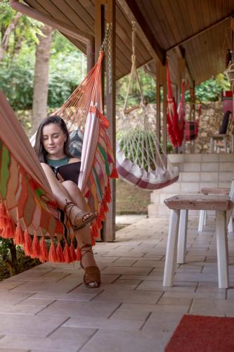 a girl is sitting in a hammock at Pousada O Cantinho da Raposa in Monte Verde