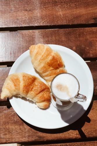 a plate with two croissants and a cup of coffee at Hotel Spa Nieves Del Cerro in Caviahue
